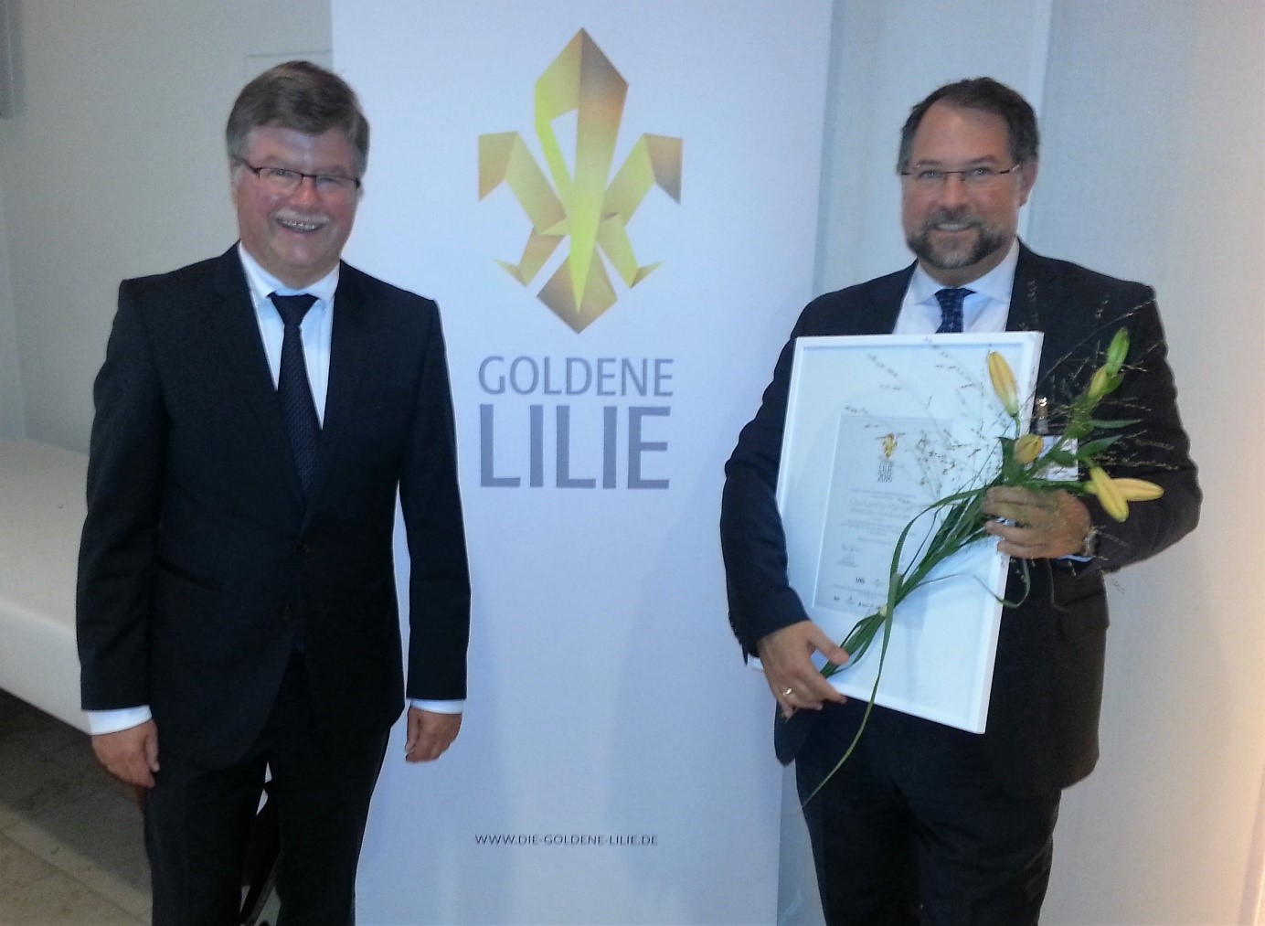 Bürgermeister Arno Goßmann (l.) und Harald Hock, General Manager (r.), bei der Verleihung der Goldenen Lilie 2016 für das Hotel Courtyard by Marriott Wiesbaden-Nordenstadt. Foto: privat